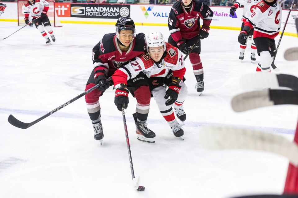 Cougars centre Riley Heidt fends off Vancouver Giants winger Cameron Schmidt during Saturday WHL action. The Cougars won 7-1 in front of a sellout crowd at CN Centre.