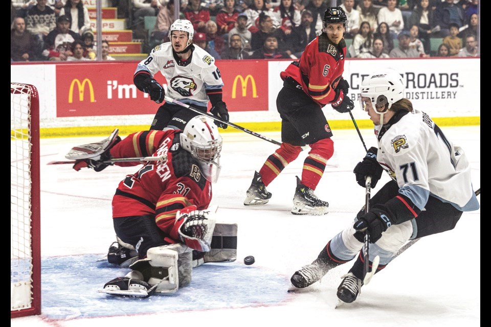 Cougars goalie Josh Ravensbergen drops to his knees to stop a shot from Portland WInterhawks shooter Josh Davies during Game 6 of the WHL Western Conference championship May 7 at CN Centre. The Cougars open training camp on Wednesday.