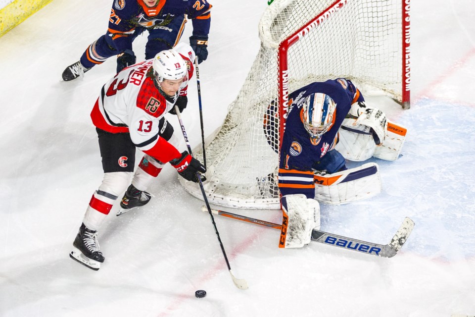 After missing 41 games with an ankle injury, Cougars winger Koehn Ziemmer returned to action Friday night in Kamloops.  Here he tires to score on Blazers goalie Jesse Sanche while forward Josh Kelly give chase from behind the net.