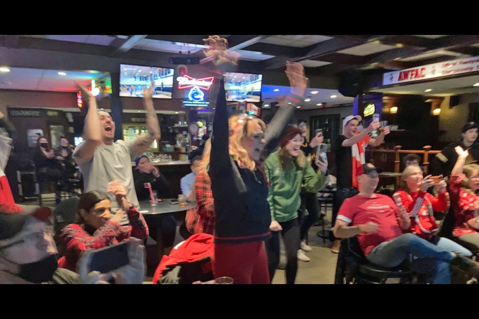 Meryeta O'Dine's mom, Virginia, centre, celebrates with friends at Westwood Pub as Meryeta captures Olympic bronze in women's snowboard cross.