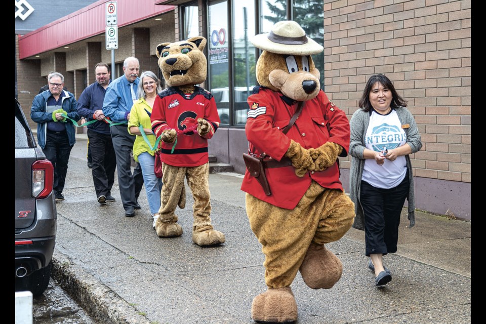 RCMP mascot Safety Bear and Etsuko Sudo-Rustad of Integris lead 'prisoners' to their lockup Wednesday to await bail being posted in support of the Prince George and District Seniors Activity Centre Society and Northern BC Children and Families Hearing Society. 