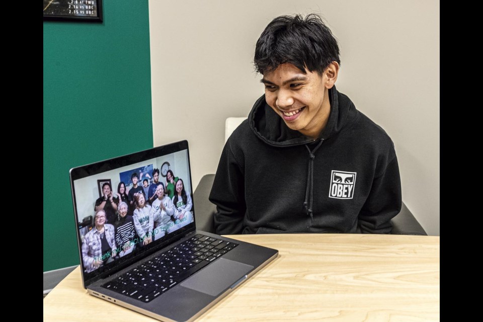 UNBC Timberwolves guard Isaiah Bias looks at the screen of a laptop showing his family who informed him he is being named to the Canada West All-Rookie team Wednesday, Feb. 26 in the UNBC Timberwolves offices.