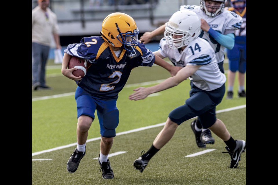 CHHS #14  breaks through the line to tackle Quesnel River Hawks #2 during a junior varsity scrimmage at Masich Place Stadium Wednesday evening.