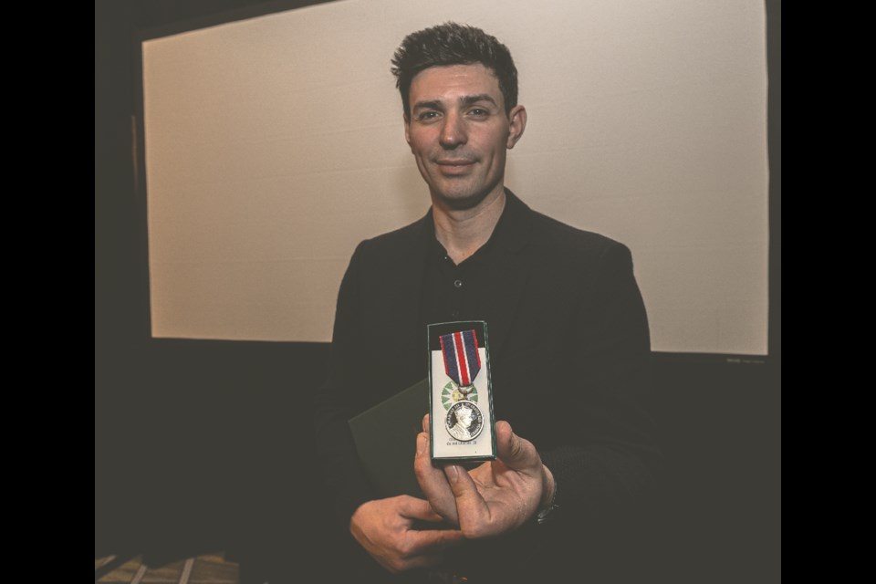 Former Montreal Canadian goalie and philanthropist Carey Price holds up his King Charles III Coronation medal on Sunday, March 9, 2025 at the Courtyard by Marriott.