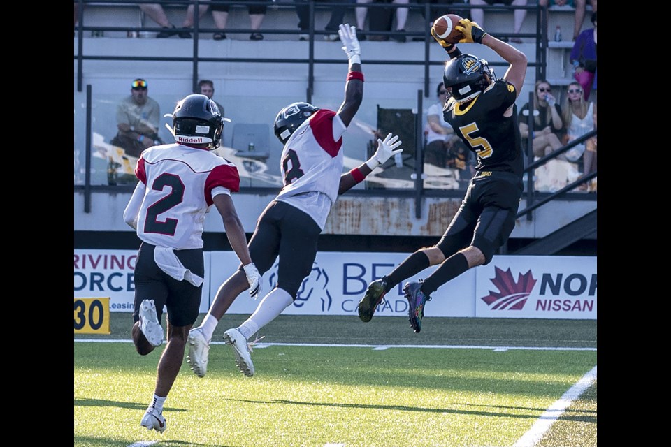 Kodiaks defensive back Taeman Piddocke picks off a pass intended for Raiders wide receiver Ruben Bonsu (No. 8) during Saturday's home opener at Masich Place Stadium.