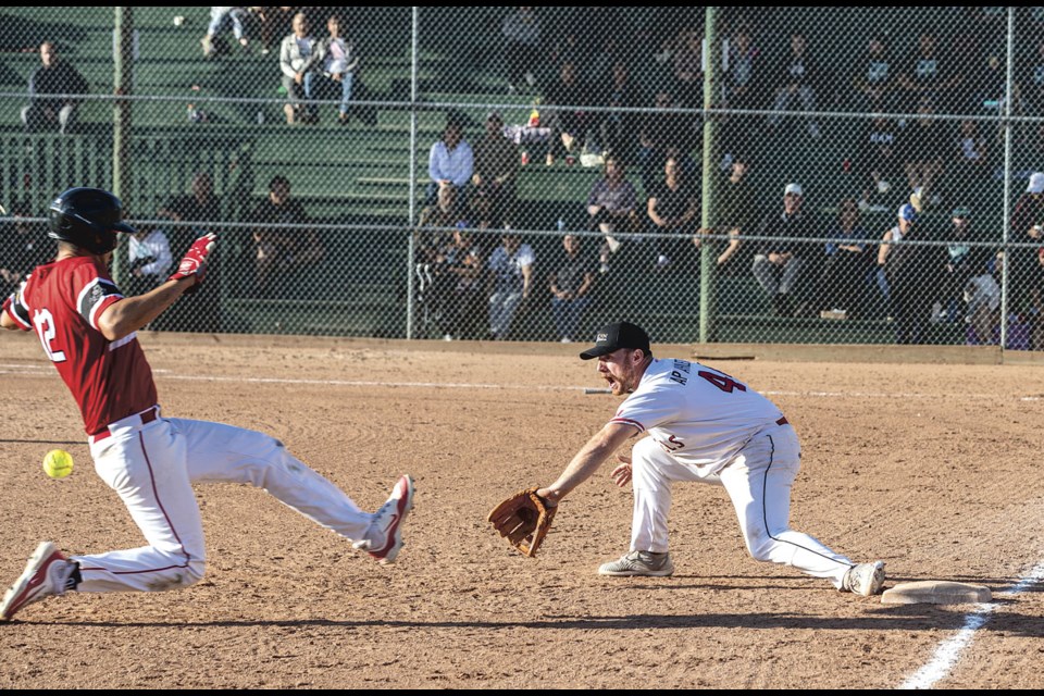 Falcon Construction Angels No. 44 Joel Walkey waits for the ball to come to him as Vanderhoof Rippers No. 12 Robbie Antoine starts his slide into third base in the final of the Kyle Garnot Memorial Tournament Sunday. The Rippers won the 12-team fastball tournament, defeating the Angels 5-2 in the final.