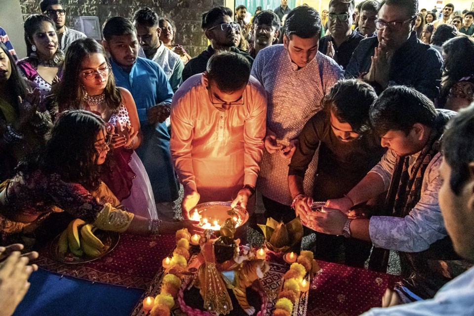 Members of the local Hindu community celebrate Navratri, an annual Hindu festival observed in honor of the goddess Durga, with Aarti (Celebration of Lights) held outside the Northern Sports Centre as they take a blessing from the goddess Friday.