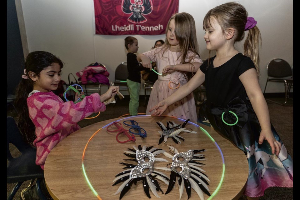 Jasmeen Sandhu, 5, (left) Elena B., 5,  and Quinn Greer-Borzel, 4, swap glasses, masks, and glowsticks at the New Year’s Boogie Monday at the Prince George Public Library main branch.