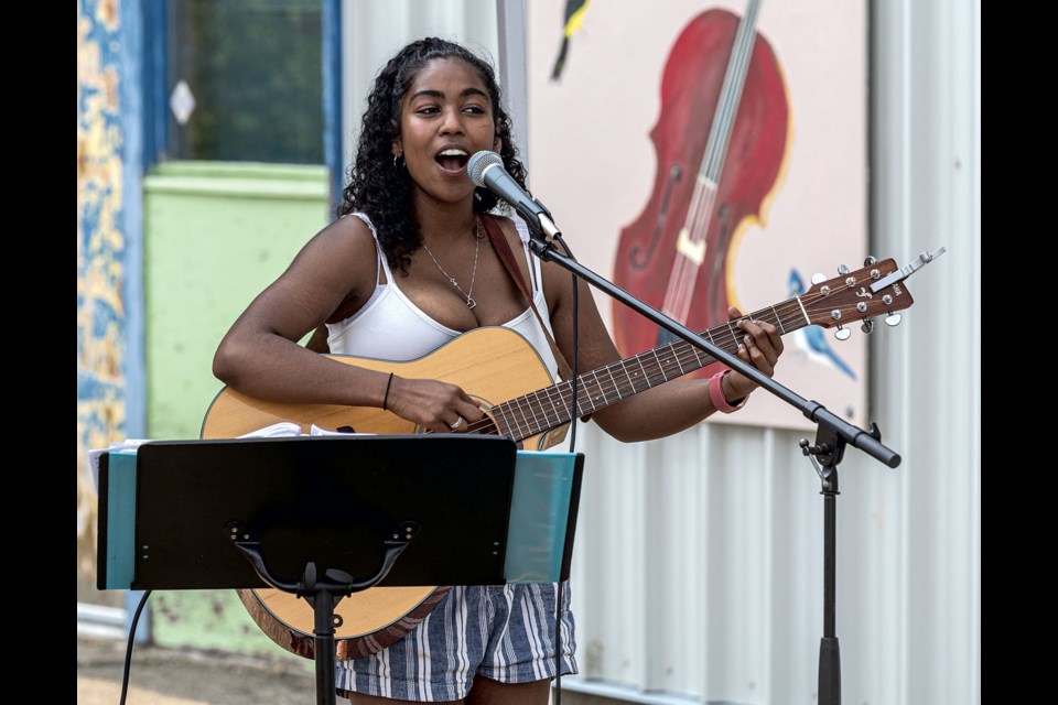 Grace Hoksburgen, 19, provided some sonic entertainment for those strolling through the many artisan and vendor booths at Studio 2880's Mid-Summer Eve Artisan Market Thursday evening.