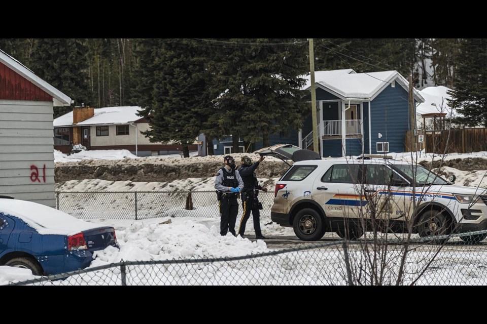 RCMP members place a packet in a waiting cruiser while wearing protective breathing masks, consistent with entering a toxic environment, outside Old Frankfurt Motel unit 21 after the Emergency Response Team had entered and cleared the building Thursday.