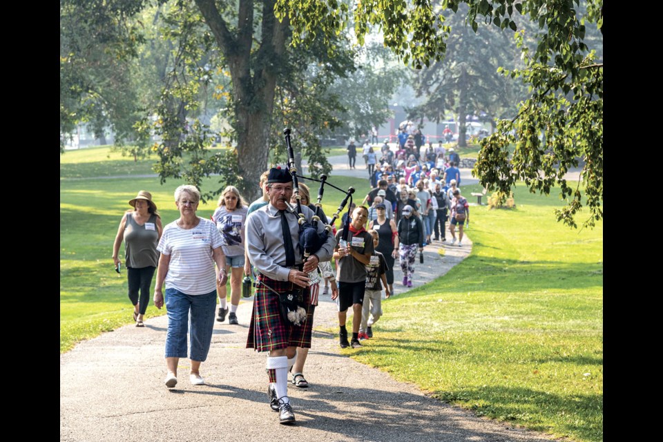 Piper Randy Carnegie leads about 40 walkers through Lheidli T'enneh Memorial Park as they set out on the Parkinson's SuperWalk around the park Saturday. 