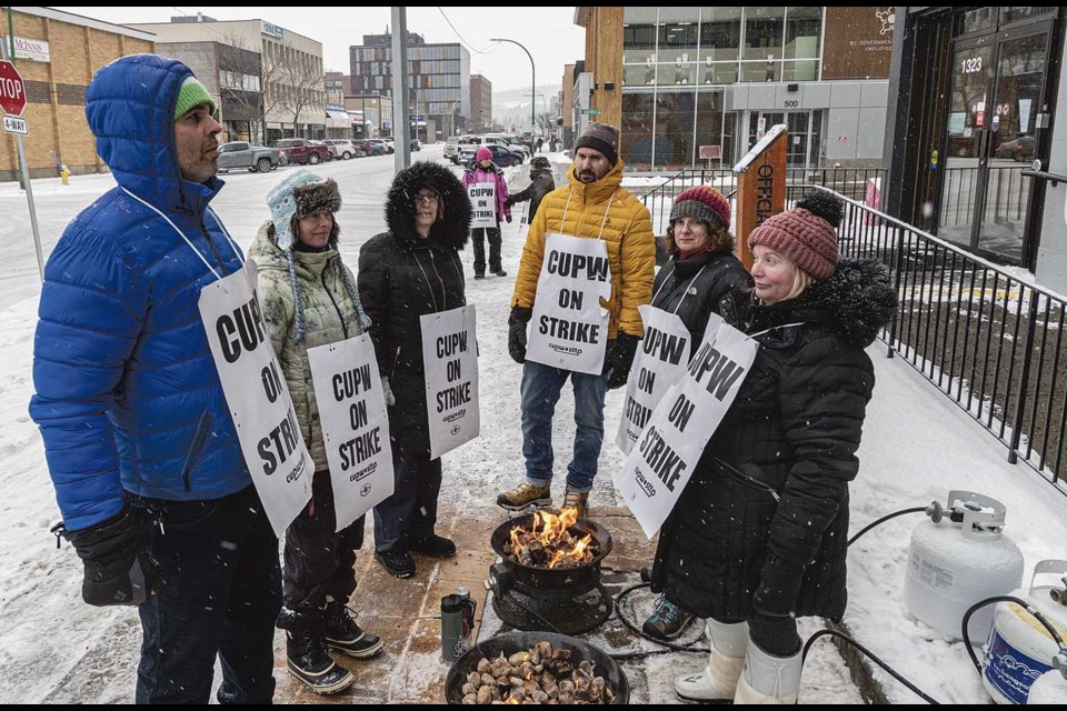 Striking postal workers gather around propane fires for warmth in front of the Fifth Avenue post office Wednesday.