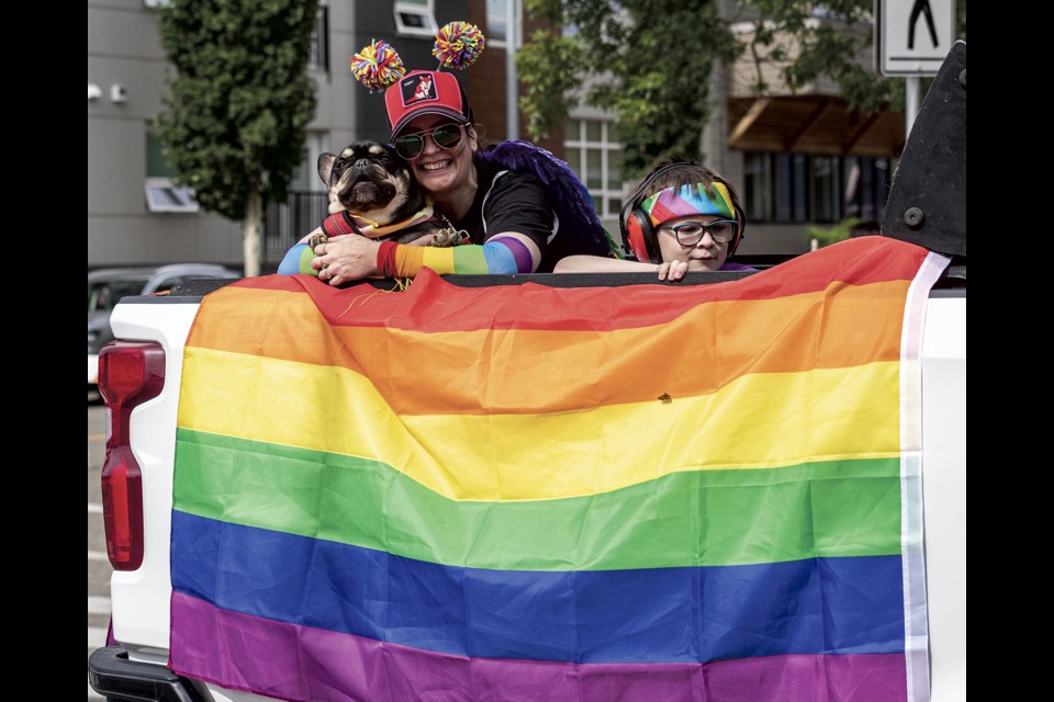 Sarah and Apollo Schleich along with Frenkenstein enjoys the music and a ride while taking part in the Pride Parade Saturday.