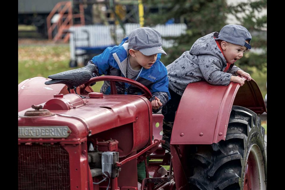 Grayson Geertsma, 4, and brother Dylan, 2, explore an old tractor while visiting the Central BC Railway and Forestry Museum Sunday for the Pumpkin Express event on Sunday, Oct. 27.