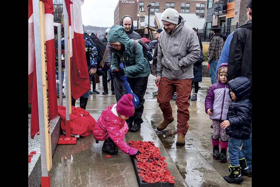 Una Scarr, 4, places her poppy at the Cenotaph following Remembrance Day ceremonies Monday.