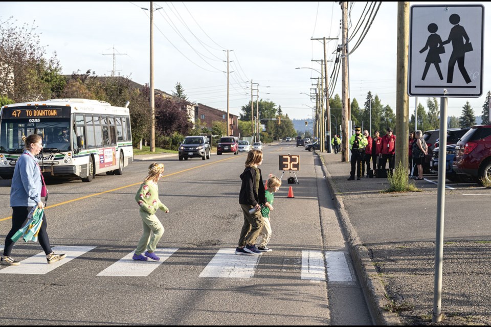 Prince George RCMP Traffic Unit officers and RCMP patrol volunteers keep an eye on drivers through the Peden Hill Elementary school zone for the first day of the new school year on Tuesday, Sept. 3, 2024 in Prince George, B.C.