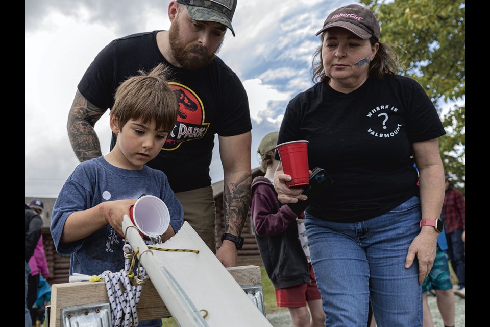 Reuben Down watches his four-year-old son Logan’s careful release of two-gram chinook salmon fry onto a water slide carrying them to the Nechako River as his grandmother Marcie looks on on Saturday, June 1, 2024 at Spruce City Wildlife Association on River Road in Prince George, B.C. 