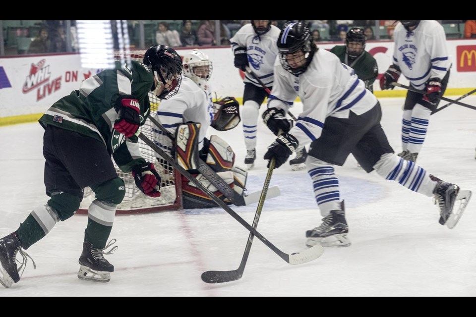 A CHSS defender lifts the stick of PGSS #9 Maddy Niesh to prevent a shot on goal Friday at the 20th Annual Spirit of Hockey & Community Cup Game between CHSS and PGSS at CN Centre. 