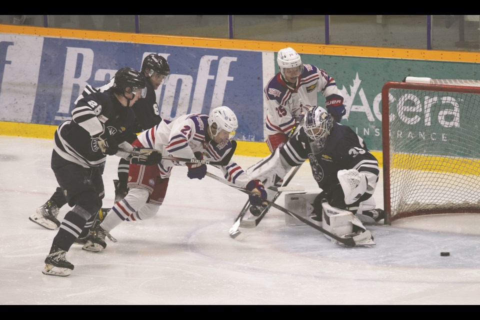 Spruce Kings forward Mason Loewen backhands a shot across the goal crease in front  Langley Rivermen goalie Bodee Weiss but ultimately gets it to cross the goal line during their preseason game at Kopar Memorial Arena in September 2024.