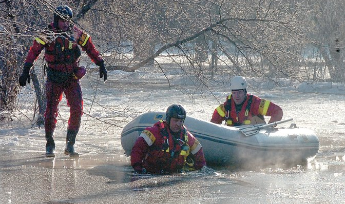 Jan. 8. 2008: Firefighters Larry Obst, Brad Johnson and Steve Fennell make the trip through icy waters to the Cutbanks Road home of Quin Skuggedal, where they rescued her cats but let her know there was water in her basement from flooding caused by the ongoing Nechako River ice jam.