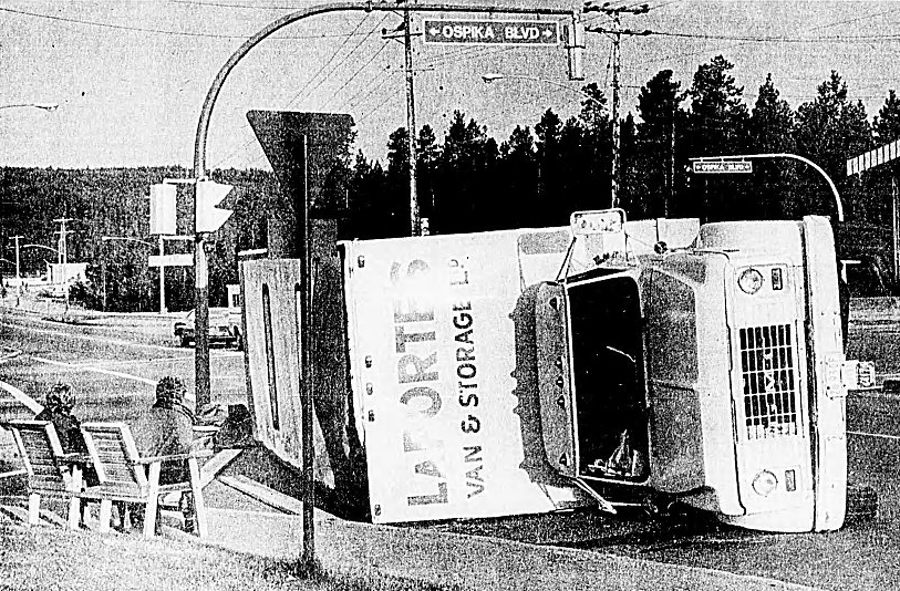 Aug. 29, 1981: Waiting for help – Sitting comfortably in chairs, the driver and swamper of an overturned furniture van wait for another truck to help unload the contents. A wrecker could not be found to put the van back on its wheels after it tipped at 5th Avenue and Ospika Boulevard. No injuries were reported. 