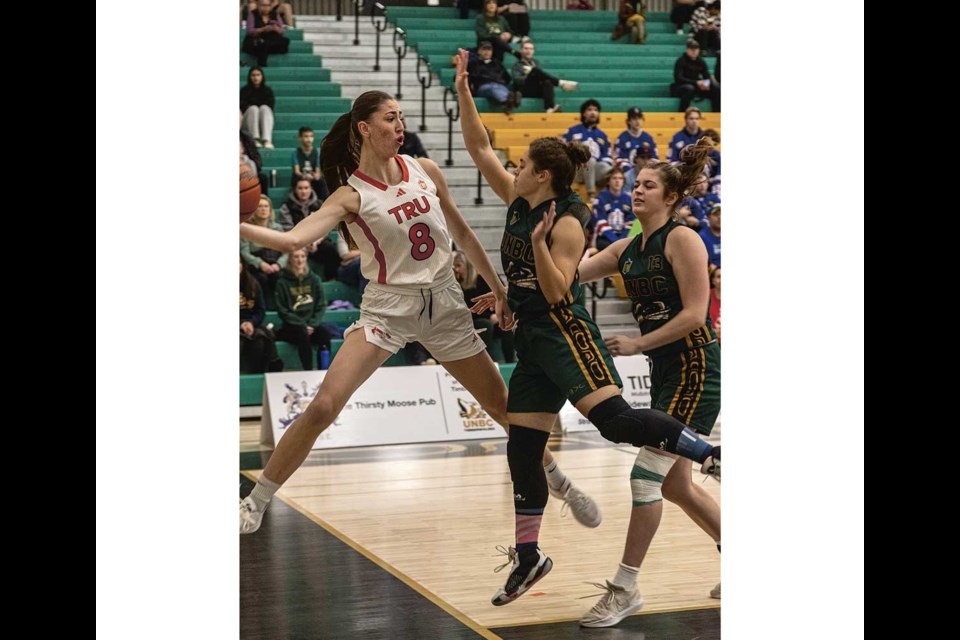 Wolfpack forward #8 Kate De La Mare leaps to hook back an out of bounds ball as Timberwolves guard Yana Shupak tries to block her Sunday at UNBC .