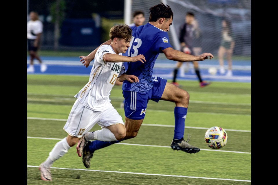 UBCO Heat # 13 Alex Sol tries to gain control of the ball ahead of Timberwolves #12 Jacob Wedel Friday at Masich Place Stadium.