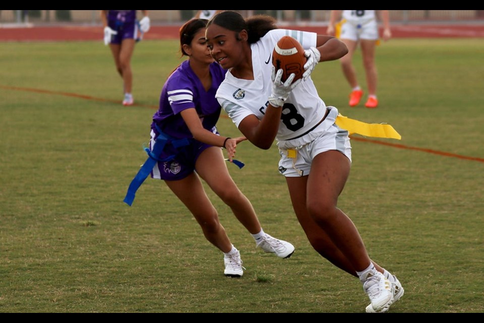 Casteel High School wide receiver Khali Boller runs along the sideline past an Arizona College Prep defender. Girls flag football became an Arizona Interscholastic Association-sanctioned sport in fall of 2023.