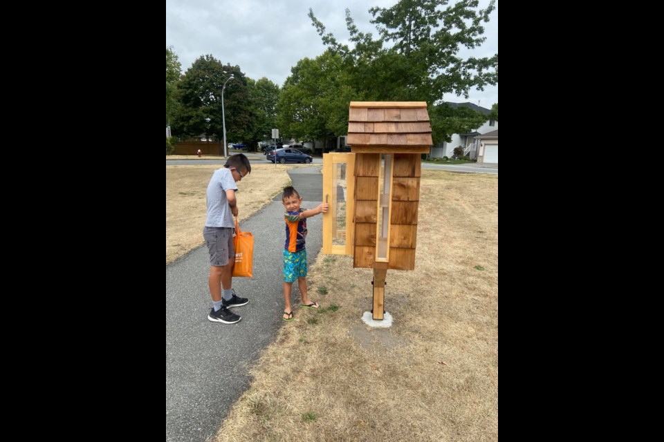 Kids spotted donating to McLean Park's new little free library.