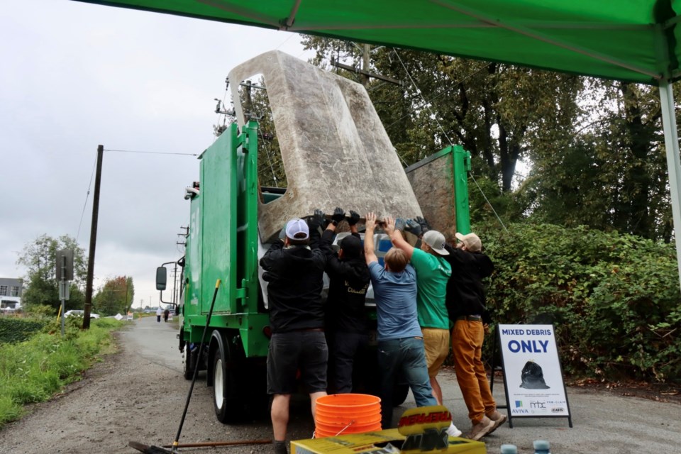 Volunteers loading a truck's canopy at the River Road location of a Richmond shoreline clean-up.