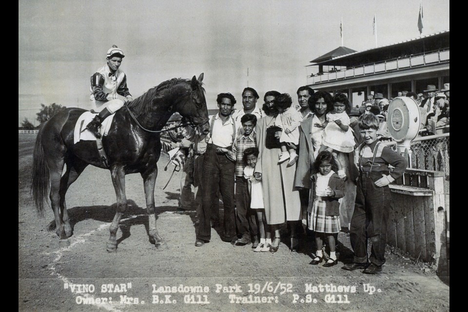 Winners Circle with horse Vino Star. Charan Gill, who's been helping the archives with this project, is in a white dress and shoes standing in the middle of the photo.