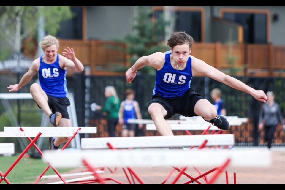 Our Lady of the Snows Catholic Academy's Brendan Walsh, left, and Lukas Baruta compete in 100-metre hurdles during the senior high regional track meet at Centennial Park in Canmore on Wednesday (May 15). JUNGMIN HAM RMO PHOTO