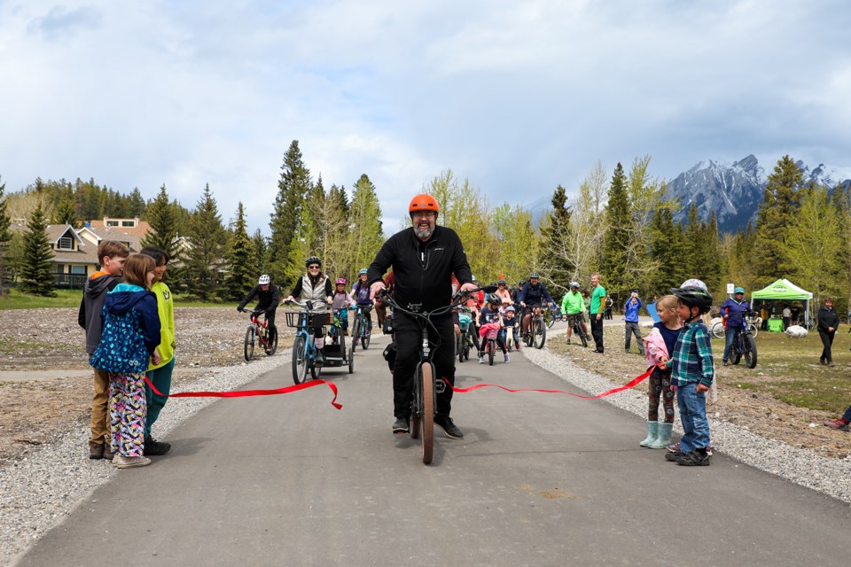 Canmore mayor Sean Krausert leads a group of cyclists to the ribbon cutting ceremony at the official opening of the West Bow River Pathway at the West Canmore Park in Canmore on Saturday (May 25). JUNGMIN HAM RMO PHOTO