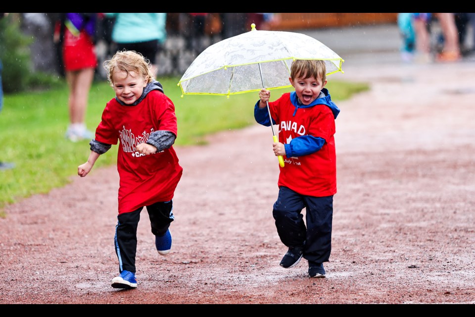 Jett Jardine, left, and Cooper Weidel have fun running in the rain in the Canada Day family fun, run and walk at Centennial Park in Canmore on Monday (July 1). JUNGMIN HAM RMO PHOTO 