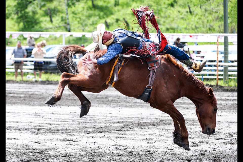 Cam Bruised Head holds on for eight seconds with one hand in the air and the other in a rigging handhold in the bareback bronc riding during the Mînî Thnî Canada Day rodeo on Monday (July 1). JUNGMIN HAM RMO PHOTO