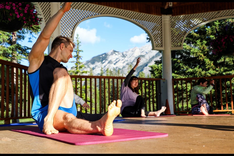 Participants take in a deep breath and stretch it out during the Yoga in the Park sessions at Central Park in Banff on Thursday (July 4). Yoga in the Park will be held Thursdays, 7:30-8:30 a.m. in Central Park in July and August. JUNGMIN HAM RMO PHOTO