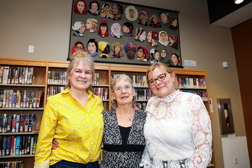 Calgary fabric artist Sharon Johnston, centre, donor Carla Cumming Sojonky, left, and The Collectors' Gallery of Art owner Romana Kaspar-Kraft pose at the unveiling ceremony at Canmore Public Library on Friday (July 12).  JUNGMIN HAM RMO PHOTO