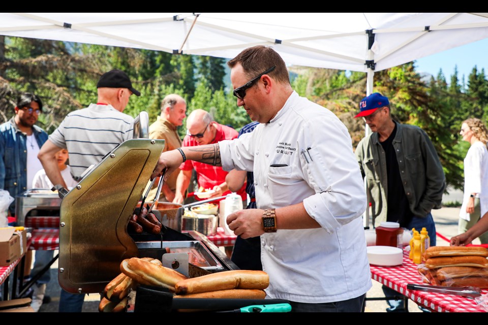 Pursuit executive chef Scott Hergott grills sausages at Pursuit's annual Stampede barbecue in Banff on Friday (July 12). JUNGMIN HAM RMO PHOTO