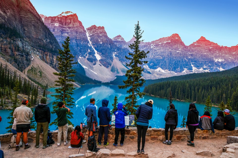 Crowds of tourists watch the sunrise at Moraine Lake in Banff National Park on Saturday (July 20). JUNGMIN HAM RMO PHOTO

