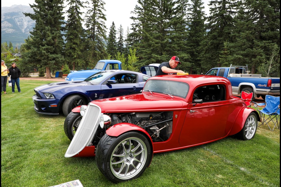 Matthew Puzey cleans the body of a 1933 Ford V8 at the 16th Annual Car & Motorcycle Show at Centennial Park in Canmore on Saturday (July 27). JUNGMIN HAM RMO PHOTO 