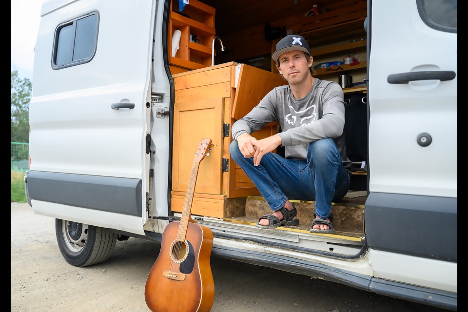 Jasper evacuee Ryan Titchener poses with his van and his guitar in Canmore on Monday (July 29).  MATTHEW THOMPSON RMO PHOTO