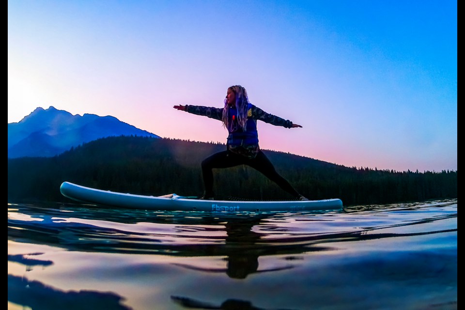 Lucy Hill exercises yoga on a paddleboard when the sun rises at Two Jack Lake in Banff National Park on Friday (Aug. 9). JUNGMIN HAM RMO PHOTO