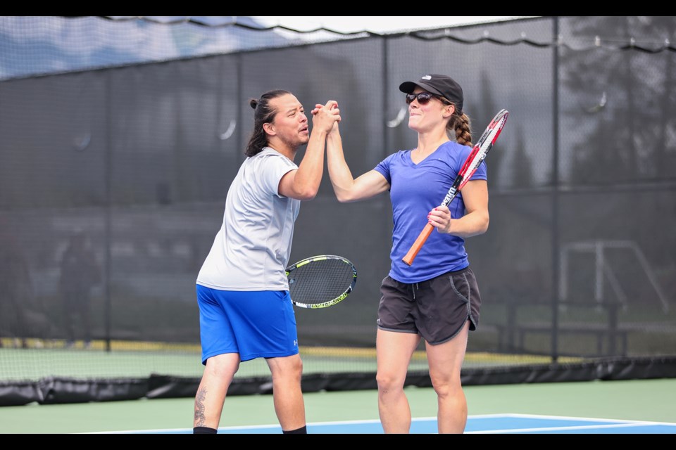 Diego Mora, left, and Marie-Pierre Boissonnault high-five after a successful attack during the Canmore Tennis Association’s Mixed Doubles club championship match at Lions Park in Canmore on Saturday (Aug. 17).  JUNGMIN HAM RMO PHOTO