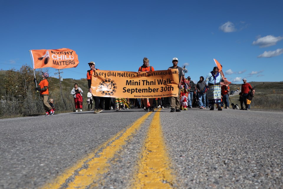 About 200 people walk down Mînî Thnî Road in Îyârhe Nakoda First Nation during the fourth annual Every Child Matters Walk, coinciding with the National Day for Truth and Reconciliation on Monday (Sept. 30). JESSICA LEE RMO PHOTO