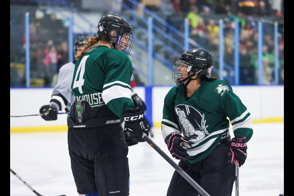 Team Vixens’ Ellen Riordan, right, and Jennifer Sisson celebrate the first goal during the showcase game on Tuesday (Jan. 14) at the Canmore Recreation Centre. JUNGMIN HAM RMO PHOTO