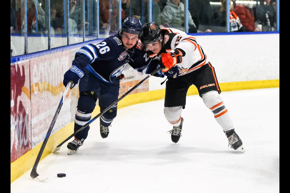 Canmore Eagles defenceman Casey Black battles for possession of the puck with Drumheller Dragons defenceman Tristan Serrao during the Scotiabank Hockey Day in Canada AJHL game at the Canmore Recreation Centre on Saturday (Jan. 18). The Eagles won 6-2. JUNGMIN HAM RMO PHOTO