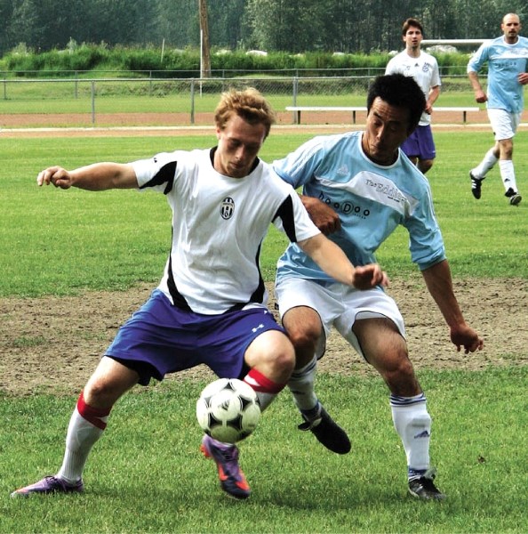 Banff FC player Kazuya Nakazawa (blue jersey) challenges a Salmon Arm Courvas player for the ball. Banff defeated Salmon Arm 2-1 in the June 18 round-robin game at the Big