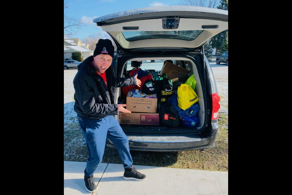 Teacher Derek Bouma shows off some of the donations from King George VI Public School's Kiwanis Builders Club Food Drive.