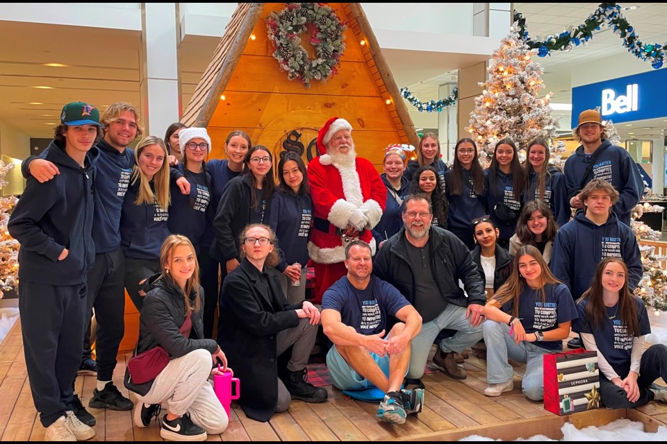 Grade 12 Leadership students in Bradon Burnham’s class pose with Santa at the Lambton Mall after Christmas shopping to brighten the season for dozens of local residents. Beside Mr. Burnham (centre) is Dave Lane with Youth Unlimited YFC Sarnia-Lambton, which donated $2,000 to the Act of Kindness Initiative.