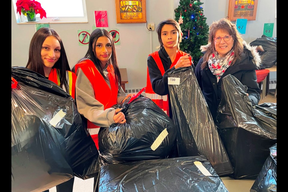 Volunteers from left: Abigail Anderson in Grade 12 at Northern, Nina Anderson in Grade 11 at Northern, Jacob Gravelle in Grade 9 at GLSS, and the Inn's board chair Sherri Crowley help prepare bags of unwrapped gifts for the Adopt-a-Family program at the Inn of the Good Shepherd. 